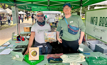 GCM Staff and Volunteer showing the GCM merch 